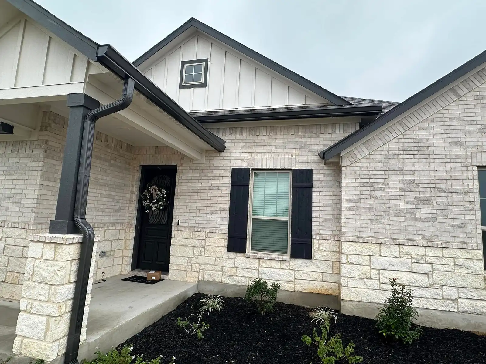 Seamless gutters installed along the roofline of a modern Texas farmhouse
